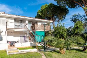 a house with a staircase and a green door at Atlantic View Apartment-El Rompido in El Rompido