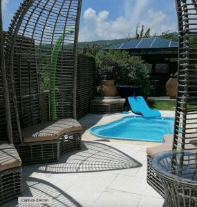 a pool with a swing and a chair next to it at VILLA La DOLCE VITA in Sainte-Marie