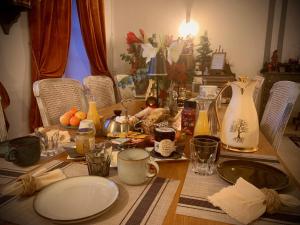 a dining room table with plates and cups on it at La Maison du Cèdre in Bénévent-lʼAbbaye