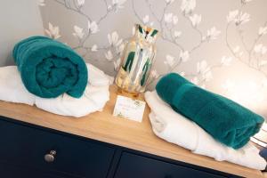 a wooden shelf with towels and a vase on it at 1 Bed in West Putford oc-thymw in Bulkworthy +14 photos