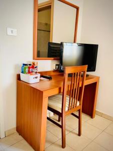 a wooden desk with a computer monitor and a chair at Smart Rooms in Molinella
