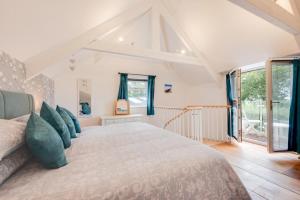 a bedroom with a large bed with blue pillows at 1 Bed in West Putford oc-thymw in Bulkworthy