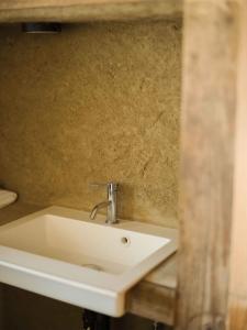 a white sink in a bathroom next to a wall at 里の宿 門後藤 in Taketa