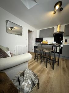 a living room with a couch and a kitchen at Rosern Short Stays in St. Ives
