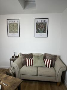a couch in a living room with two pictures on the wall at Rosern Short Stays in St. Ives