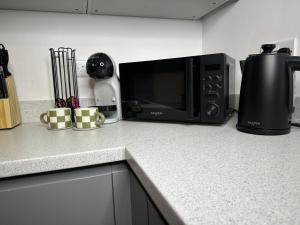 a kitchen counter with a microwave and a coffee maker at Rosern Short Stays in St. Ives
