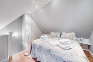 a white bedroom with a bed with white sheets and pillows at Fernsicht in Morsum