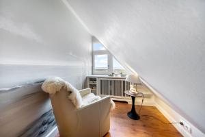 a white room with a chair and a window at Fernsicht in Morsum