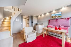 a living room with a pink couch and a table at Fernsicht in Morsum