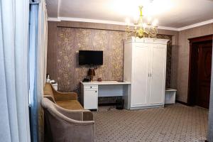 a room with a desk and a tv on a wall at ORZU HOTEL in Namangan