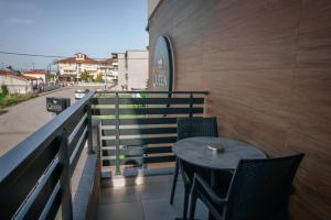 a table and chairs on a balcony with a street at Elizabeth Queen Luxury Rooms in Paralia Katerinis +28 photos