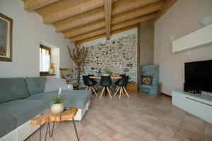 a living room with a couch and a table and a fireplace at Casa Al Castagneto in Ceniga