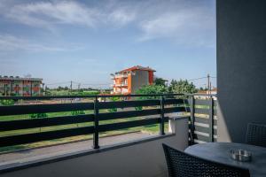 a balcony with a table and a view of a train at Elizabeth Queen Luxury Rooms in Paralia Katerinis