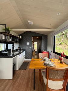 a kitchen and dining room with a table in a tiny house at Eco Tiny Latitude 28 in Urubici