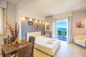 a bedroom with a bed and a table with a dining room at Ionian Balcony Hotel Apartments in Khavdháta