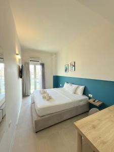a bedroom with a large bed and a blue wall at The Convo Athens Riviera in Athens