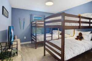 two bunk beds in a room with blue walls at Stunning 4BR at ChampionsGate - Pool & BBQ in Kissimmee