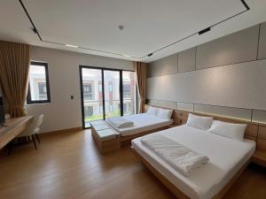 a bedroom with two beds and a desk and window at C&M Hotel in Phan Rang–Tháp Chàm +69 photos