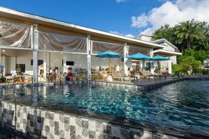 a pool at a resort with chairs and umbrellas at Three Trees Samui Resort - Sarocha Villa in Lamai
