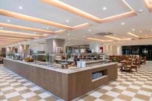 a restaurant with a counter and tables and chairs at Capsis Hotel Thessaloniki in Thessaloniki