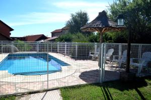 a fence with an umbrella and a swimming pool at Cabañas Quilquelen in Merlo +34 photos