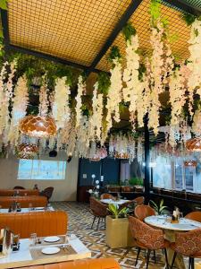 a restaurant with white flowers hanging from the ceiling at Hotel Ganga Pearl in Rishīkesh