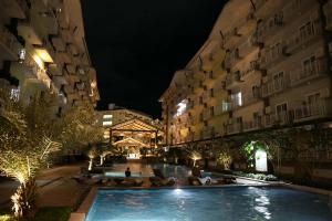 a swimming pool in the middle of two buildings at night at Lolit cozy condo in Lapu Lapu City