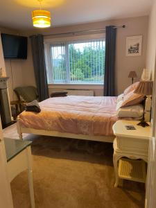 a bedroom with a large bed and a window at Gramhor House in Dumfries