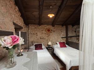 a bedroom with two beds and a vase of flowers at Mas Cal Sastre in Sant Hilari Sacalm +139 photos