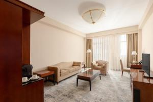 a living room with a couch and a table at Ramada Plaza by Wyndham Gence in Ganja