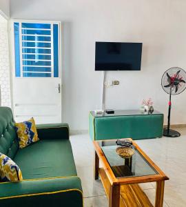 a living room with a green couch and a table at Résidence NECTAR 3 in Bouaké