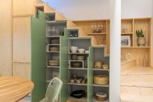 a room with a green book shelf with dishes at Lobo do Mar in Viana do Castelo +13 photos