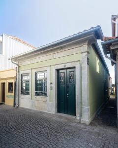 a building with green doors on a street at Lobo do Mar in Viana do Castelo
