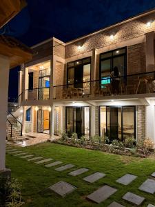 a woman sitting on a balcony of a house at night at JND Cozy Homes in Iringa