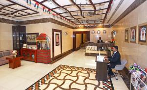 a man sitting at a counter in a lobby at Icon Hotel Apartments in Dubai +30 photos