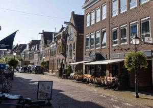 a cobblestone street in a town with a building at Hampshire Hotel Petit Nord in Hoorn