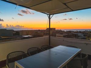 a table and chairs on a balcony with a sunset at Casa Lo Bianco in Terrasini