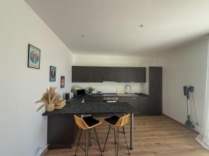 a kitchen with a black counter and chairs in it at Casa Lo Bianco in Terrasini