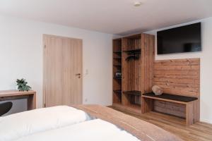 a bedroom with a bed and a tv on a wall at Ferienwohnung Beim Paschamarte in Schwangau