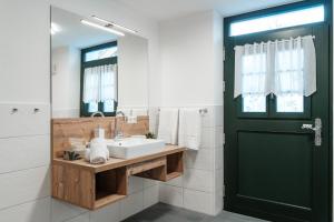 a bathroom with a sink and a black door at Ferienwohnung Beim Paschamarte in Schwangau +15 photos