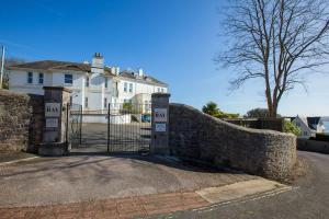 a gate in a stone wall in front of a house at Breathtaking Views at The Bay in Torquay