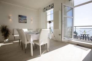 a dining room with a white table and white chairs at Breathtaking Views at The Bay in Torquay +52 photos