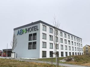 a white building with an am hotel written on it at ABN Hotel by WMM Hotels in Altdorf bei Nuernberg +15 photos