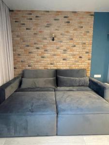 a couch in a room with a brick wall at Sky City room in Odesa