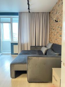 a bedroom with a large bed and a brick wall at Sky City room in Odesa