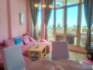 a living room with a pink couch and a table at Barbie-Themed 3BDR Penthouse Near The Beach, Nessebar in Nesebar