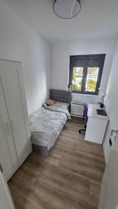 a bedroom with a bed and a desk and a window at Forest Edge Lake House in Desmerice