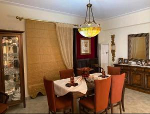 a dining room with a table and chairs and a chandelier at Stone Horizon Villa in Eretria