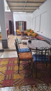 a room with a table and chairs and a rug at Hostel Capital in Rabat