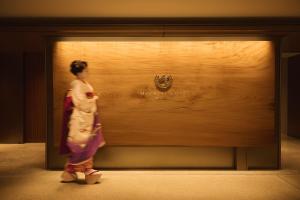 a woman in a kimono standing in front of a window at Imperial Hotel, Kyoto in Kyoto